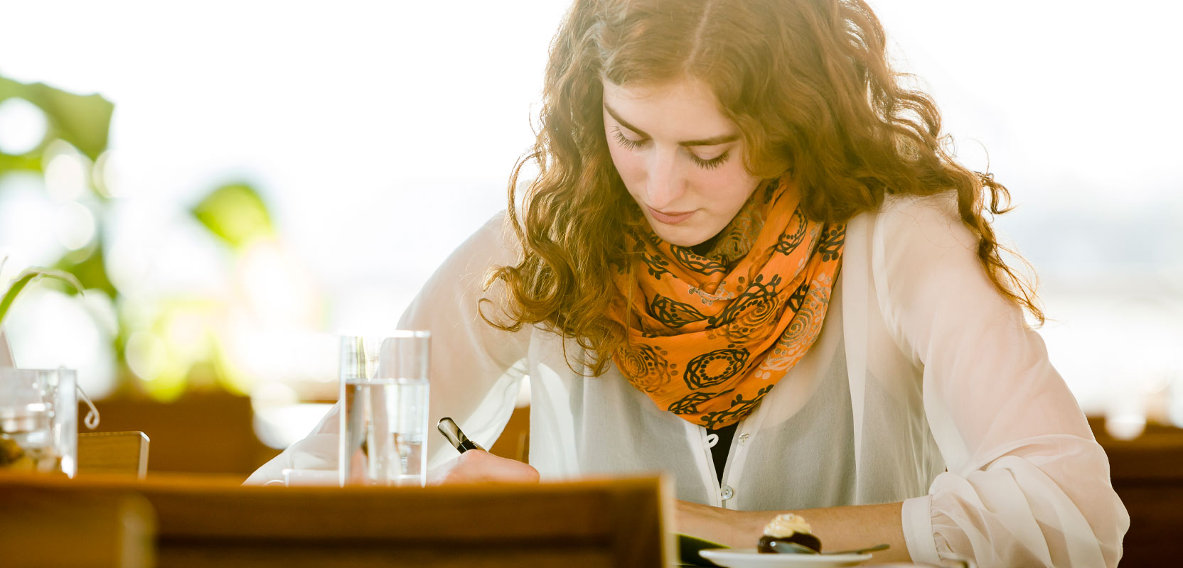 Mother writing in a notebook for her ghostwriting gig