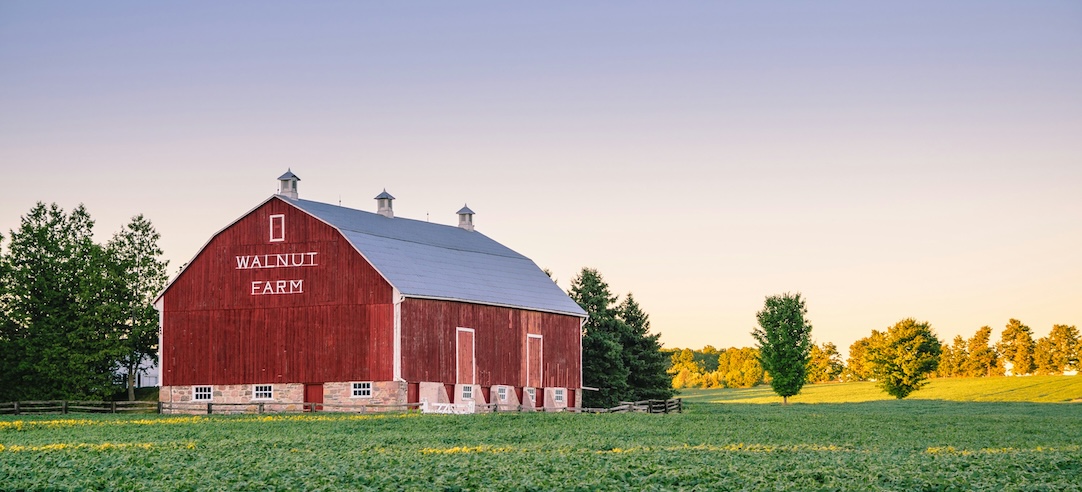 A red barn in the middle of a field.