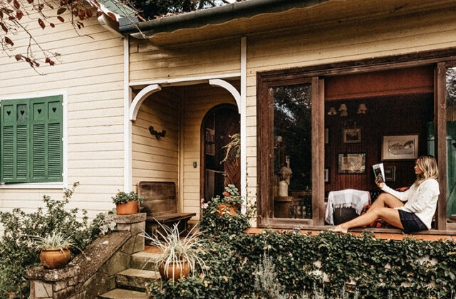 House sitter reading a book outside during a house sitting stay