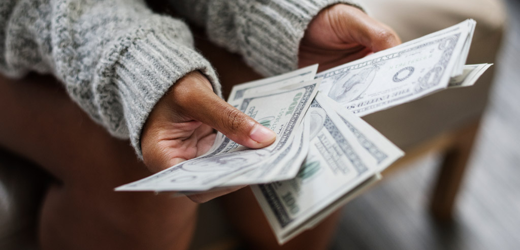 Close view of hands holding several dollar bills