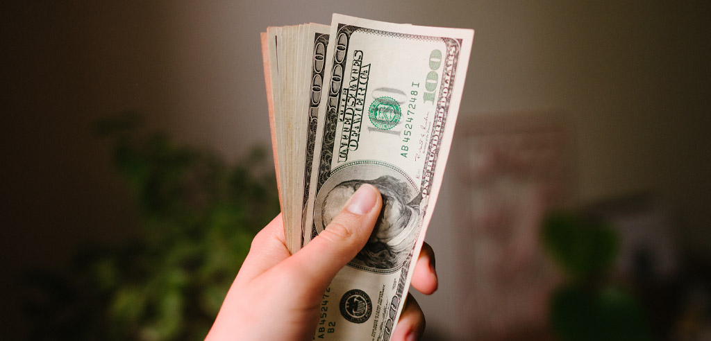 Close view of a hand holding hundred dollar bills