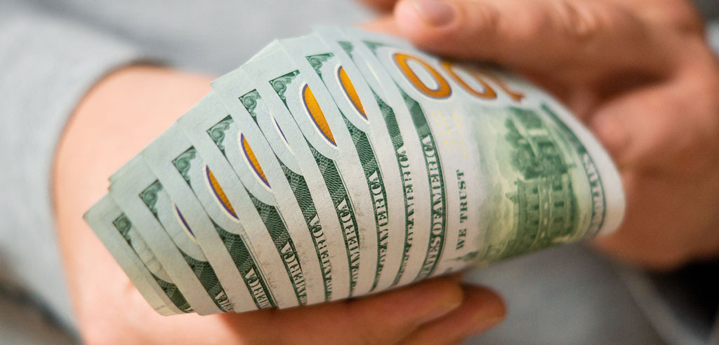 Closeup of a stack of hundred-dollar bills in someone's hands