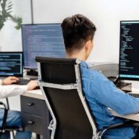Two web designers sitting in front of large computer monitors