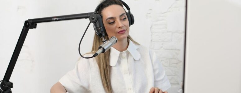 Professional content creator wearing headphones and sitting at a desk with a keyboard, mouse, and microphone