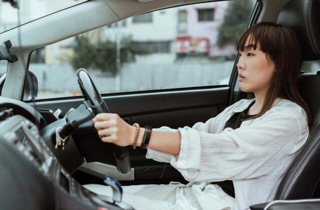 Driver's ed student driving in the front seat of a car and looking focused on the road