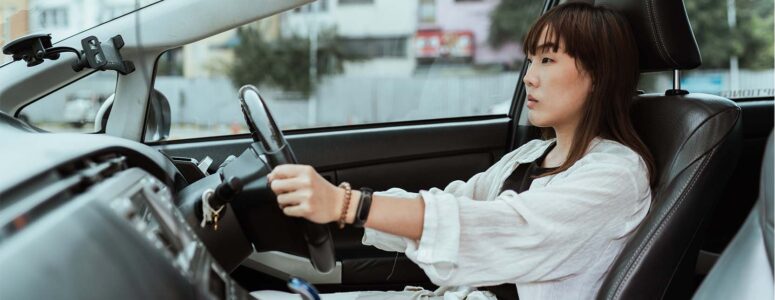 Driver's ed student driving in the front seat of a car and looking focused on the road
