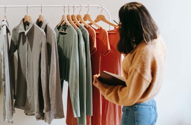 Professional personal shopper sifting through clothes on a rack to buy for a client