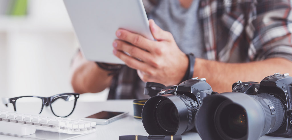 Photographer at a desk reading information online