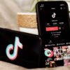 Two smartphones displaying the TikTok logo and profile page for a paid TikToker