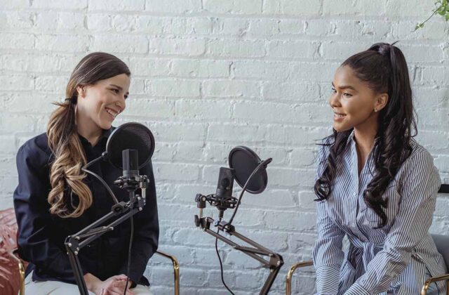 Two podcasters making a podcast in a studio with professional recording equipment