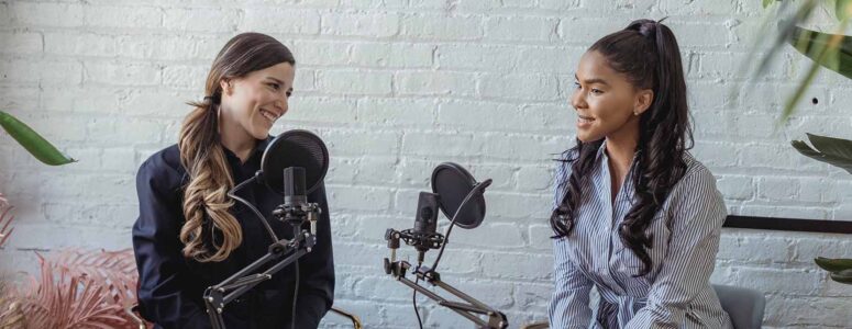 Two podcasters making a podcast in a studio with professional recording equipment