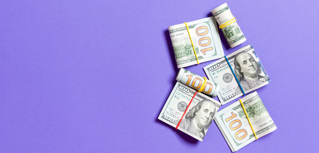 Hundred dollar bills rolled up with rubber bands