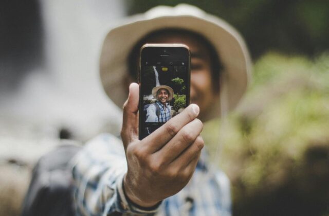 View of an influencer through the lens of a smartphone, which they're holding up to record a social media post