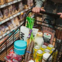 Instacart shopper pushing a cart full of groceries.