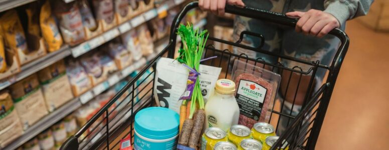 Instacart shopper pushing a cart full of groceries.