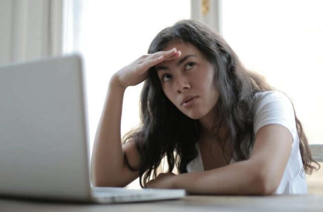 Image of a woman who is dissatisfied with her job on her laptop.
