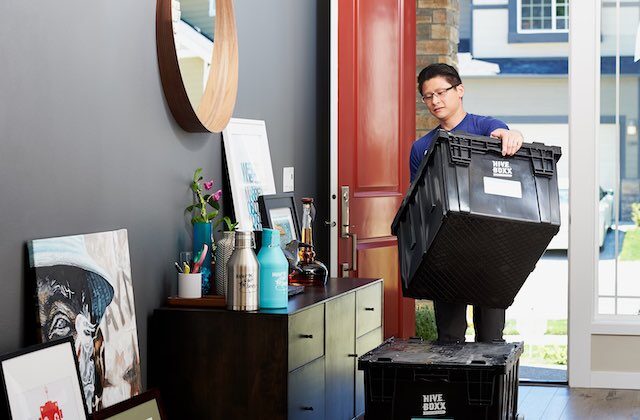 Lugg worker moving packed boxes in a house in preparation for a move.