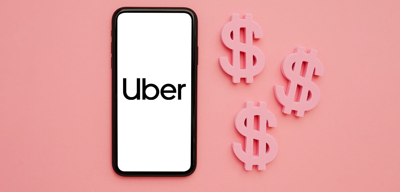 Smartphone showing the Uber app next to dollar signs