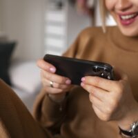 Woman testing a Mistplay game on her smartphone.