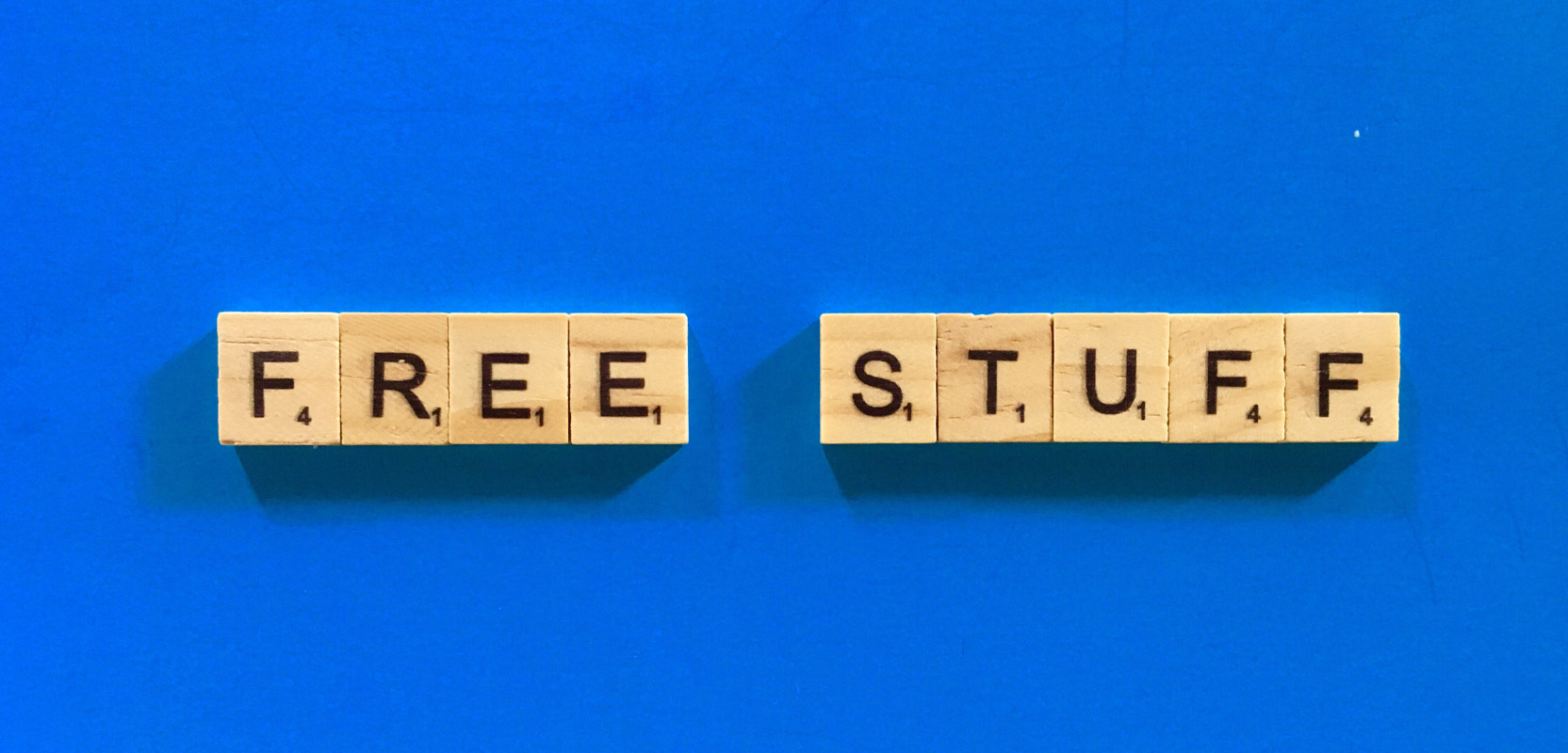 Scrabble chip spelling out the words Free Stuff