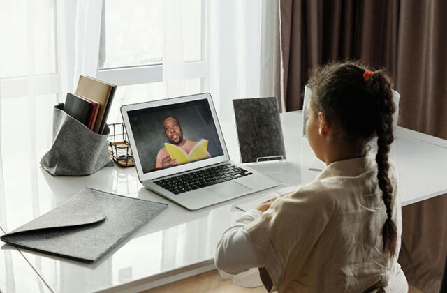 Child learner sitting at a desk and watching a prerecorded online course sold online