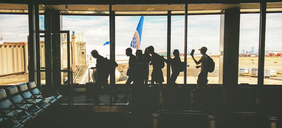 Image of passengers walking toward the gate at an airport.