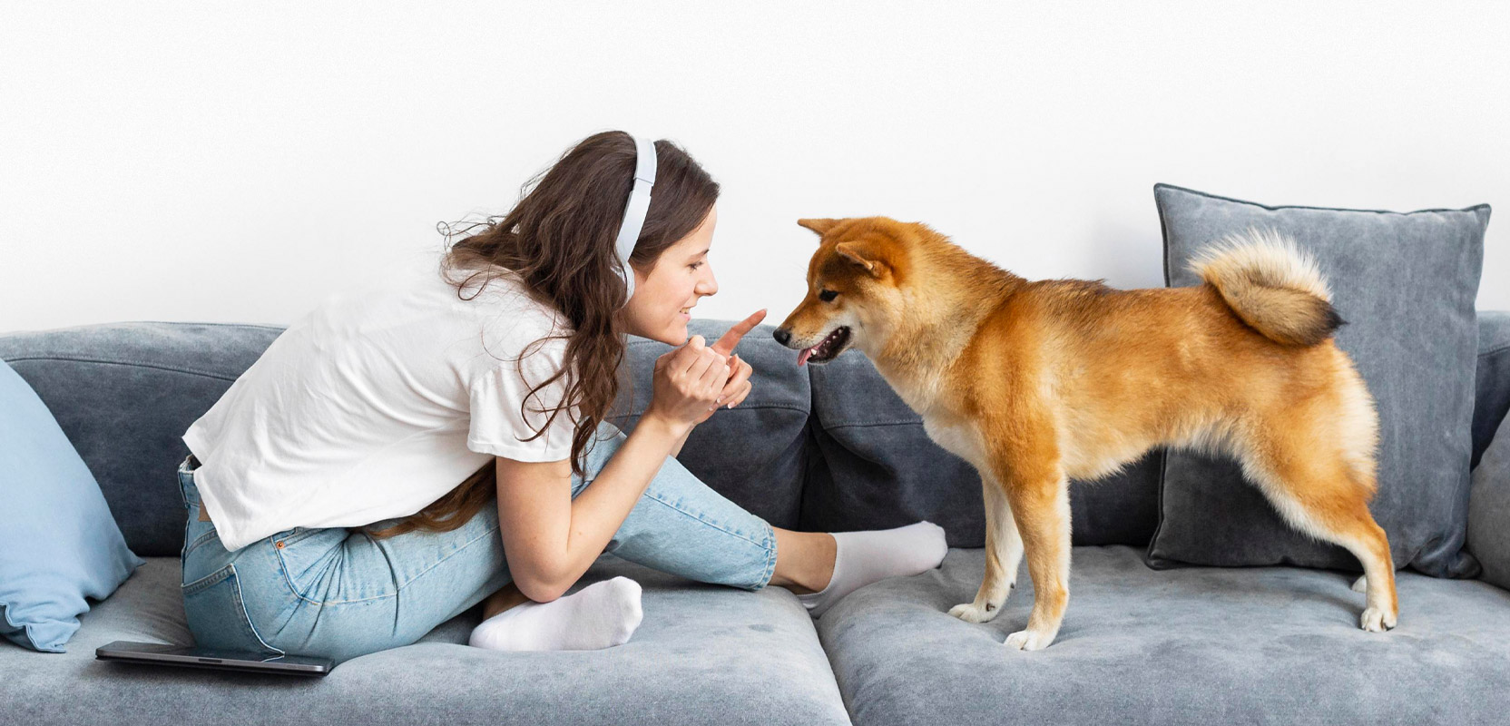 Pet sitter on a couch with a dog they're taking care of for their side hustle