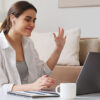 Mother sitting at her laptop earning money with her side hustle as a virtual assistant.