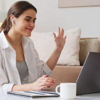 Mother sitting at her laptop earning money with her side hustle as a virtual assistant.