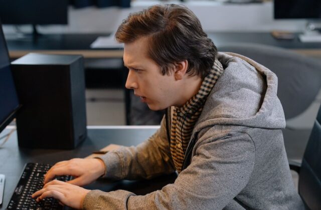 Programmer writing code on an office computer.