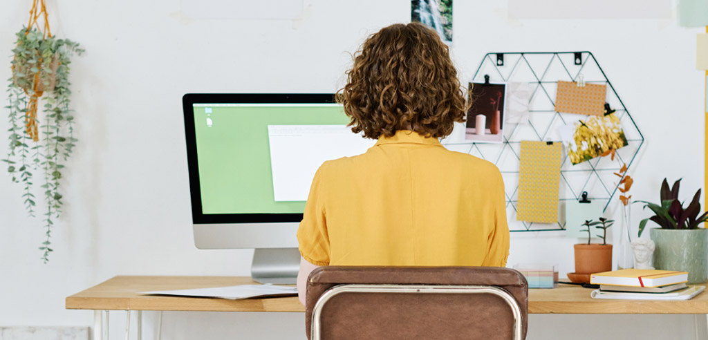 Woman working at a computer on her side hustle