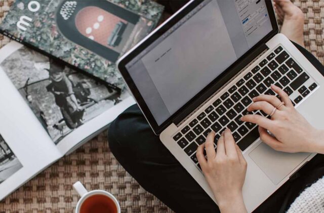 writer with hands on laptop submitting articles to publications