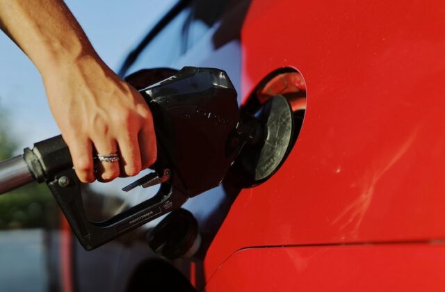 Closeup of a person pumping gas into their car.