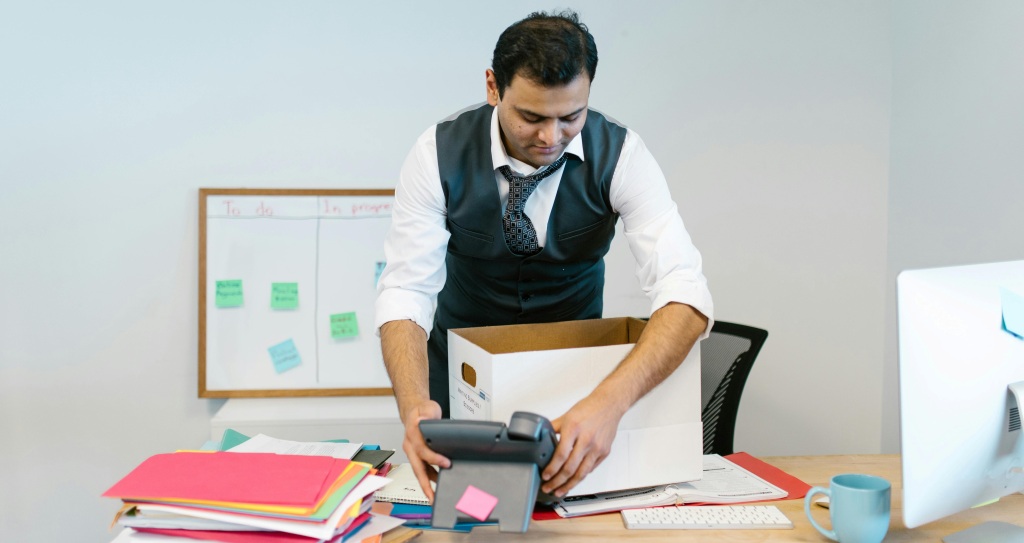 A worker packing their personal belongings in a box after quitting.