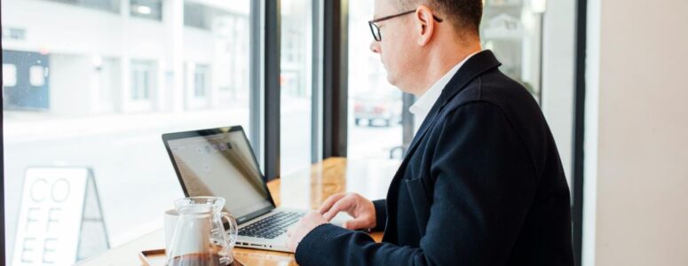 Real estate virtual assistant working on his laptop at a coffee shop.