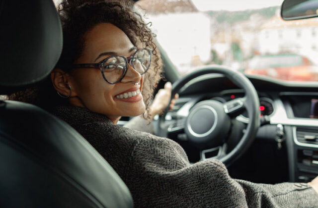 Rideshare driver looking over their shoulder in their car.