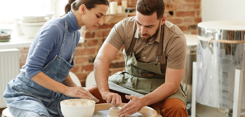 Man and woman in a workshop crafting something to sell for their side hustle