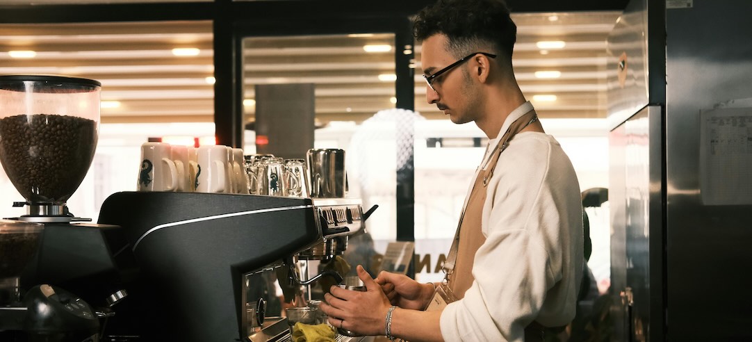 A barista making a cup of coffee.