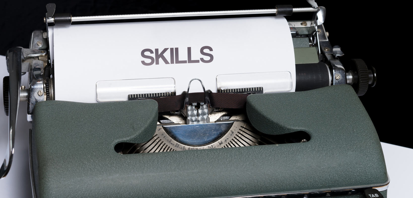 Piece of paper reading Skills stuck in a green typewriter