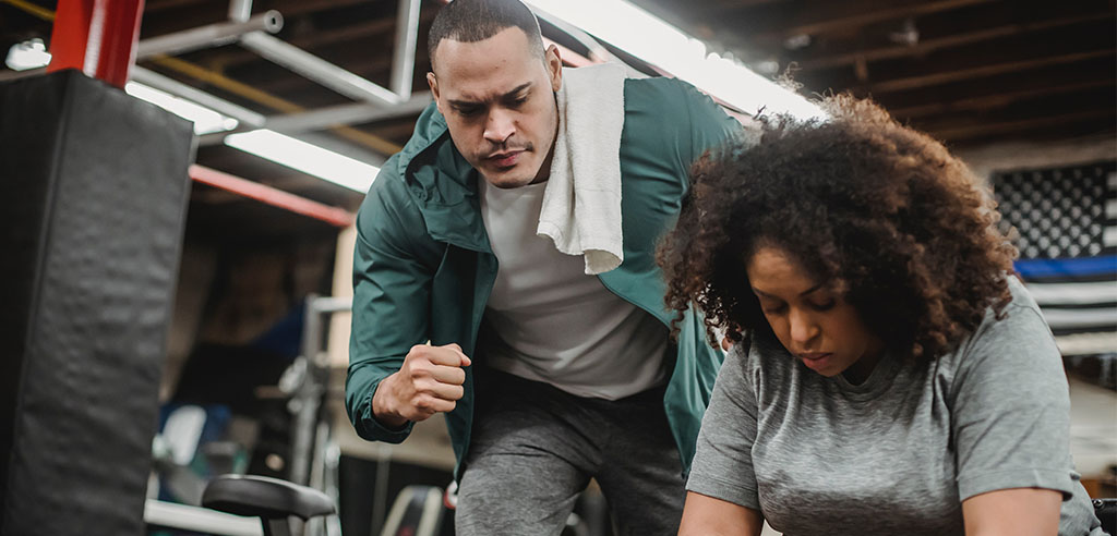 a personal trainer is cheering his client