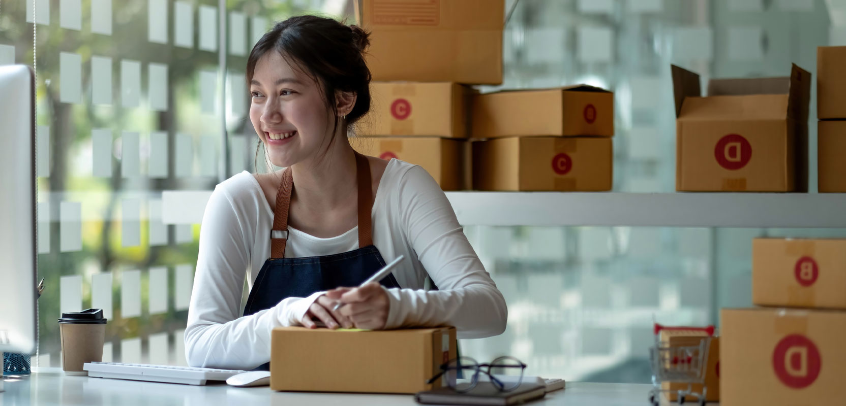 Female freelancer writing a shipping label on a box as part of her side hustle