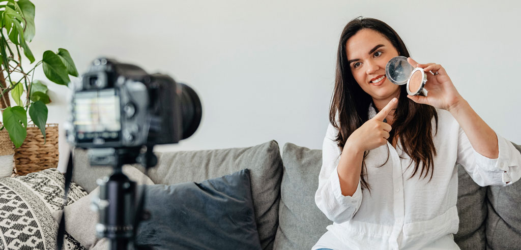 Mother facing camera and giving a presentation on makeup for her YouTube channel