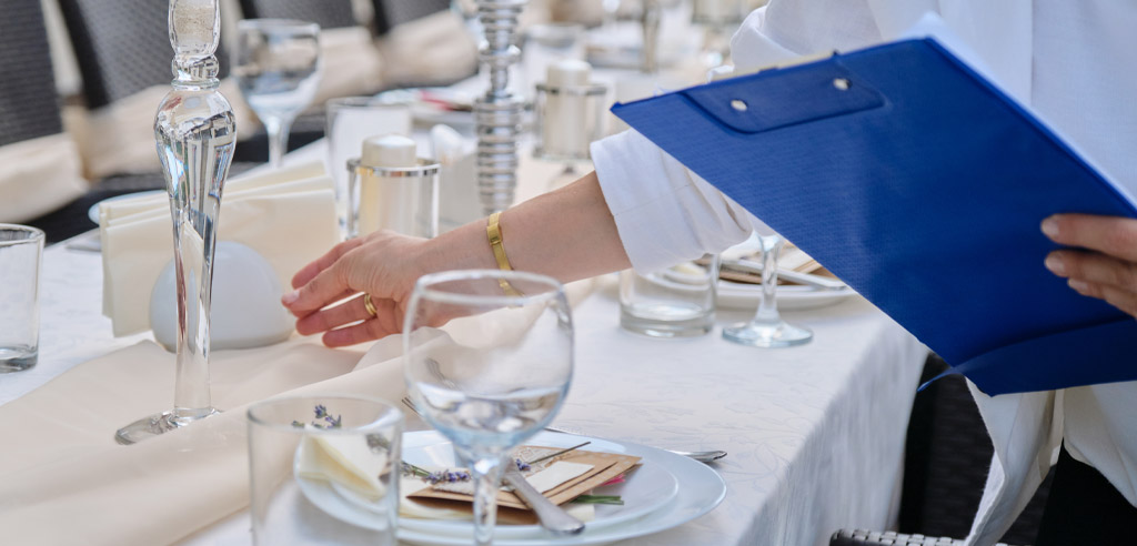 Event planner organizing tableware inside a venue