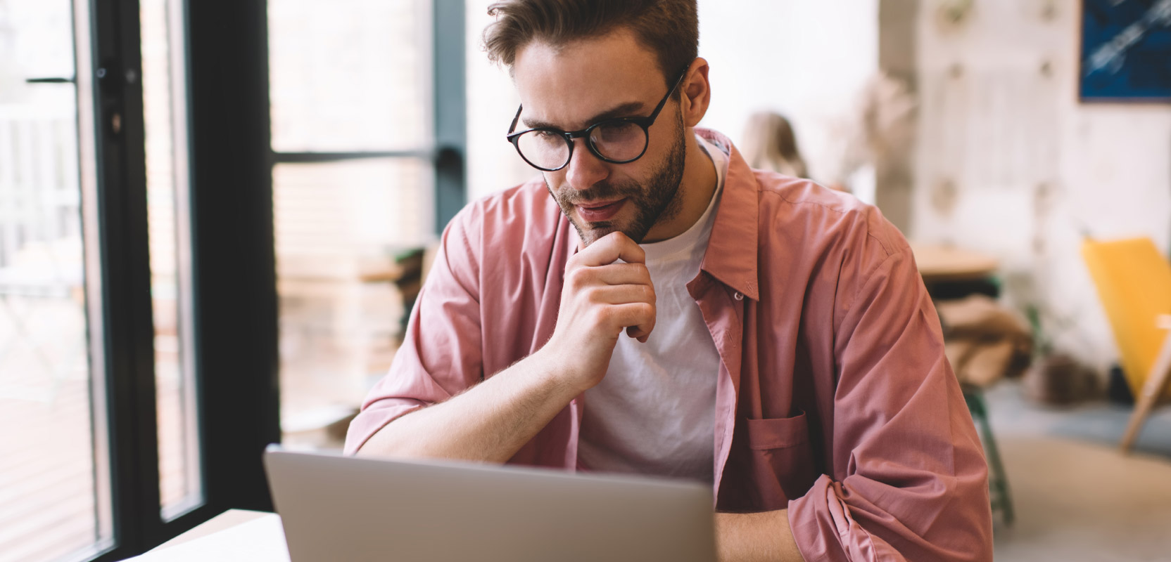 Man staring at a laptop in the process of writing a review for money