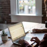 Virtual assistant working on a task at their desk while tracking their time with software tools.