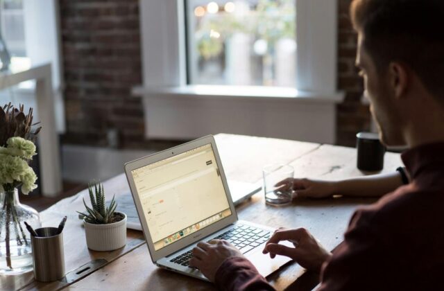 Virtual assistant working on a task at their desk while tracking their time with software tools.