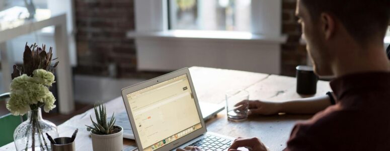 Virtual assistant working on a task at their desk while tracking their time with software tools.