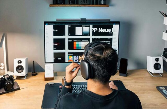 Web designer sitting at a computer, working on their remote web design side hustle