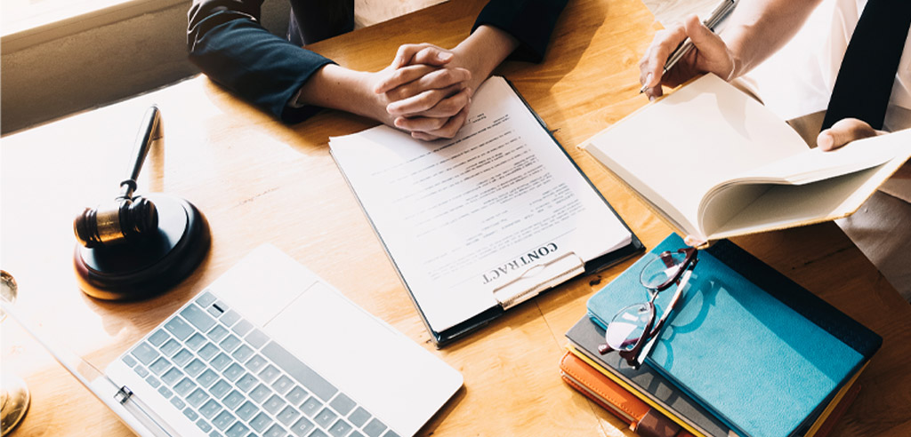 Mobile notary clasping their hands on a desk over a contract