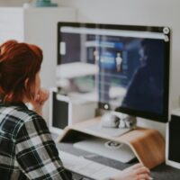 Data entry clerk sitting at a desktop computer working on their side hustle.